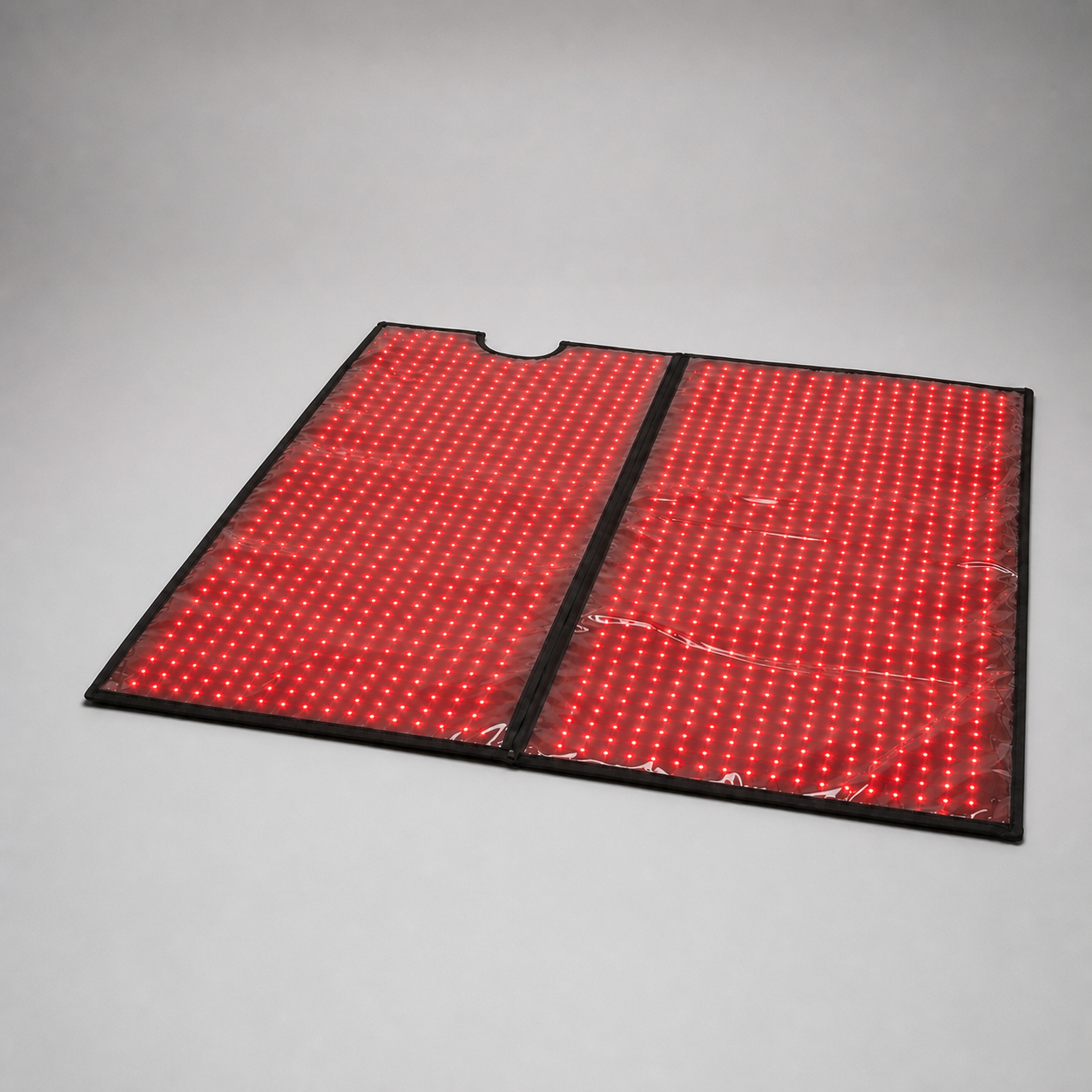 Luscent red and infrared light therapy blanket opened to show its illuminated inner surface