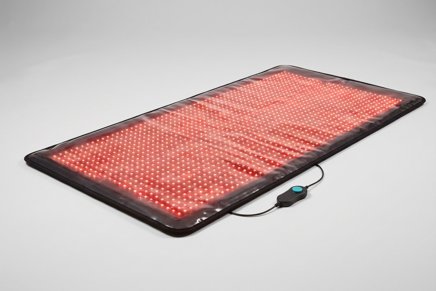 The full HigherDOSE full body red light therapy mat laid flat with every LED glowing