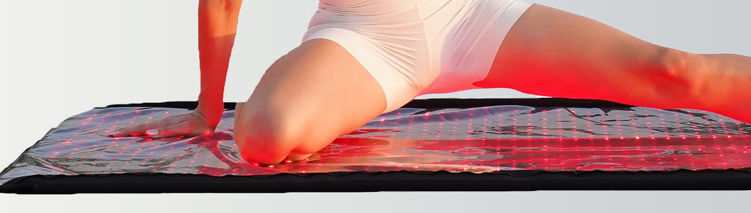 Woman kneeling in a stretch on the glowing Swirise LED therapy mat
