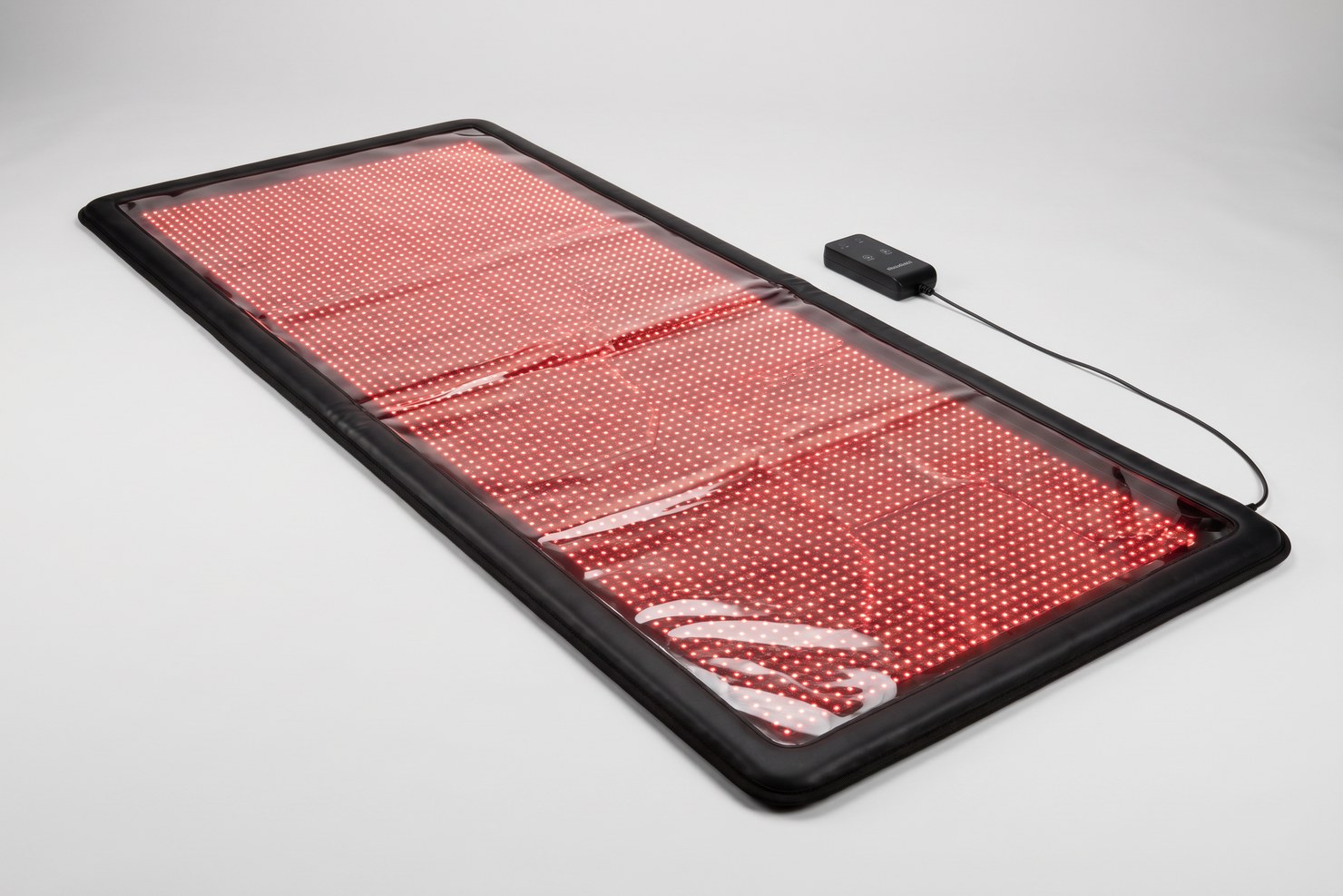 The full Swirise Mat Pro red light therapy mat laid flat under a glossy top with every LED glowing